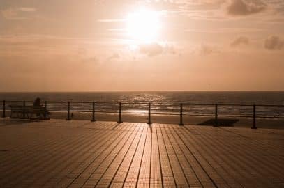 sunset on the embankment in the oostende and the silhouettes of one man on a bunch